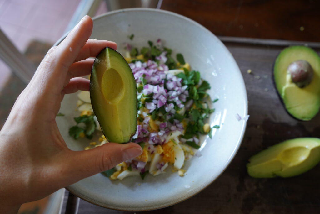 add the avocado to the egg salad bowl