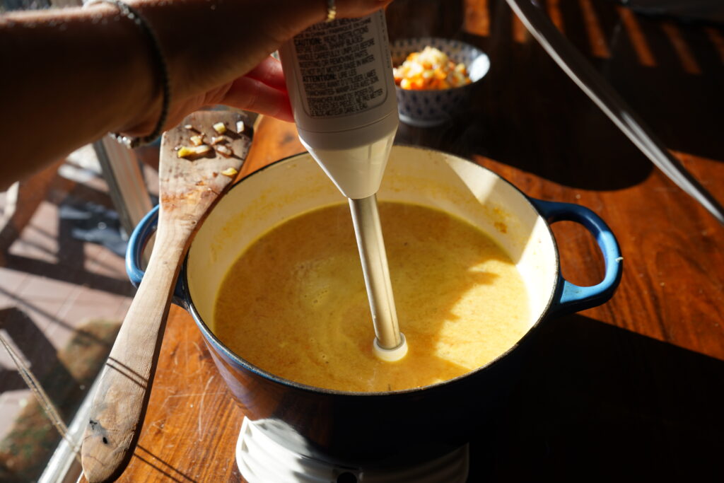 an immersion blender in a pot of soup