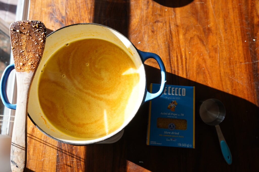 a pot of soup with a wooden spoon balancing on the handle