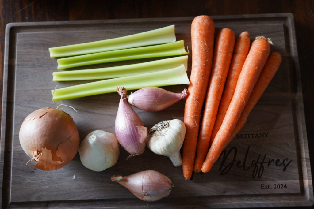 Celery, carrots, onions, shallots and garlic ready to be chopped for the whole baked chicken recipe.