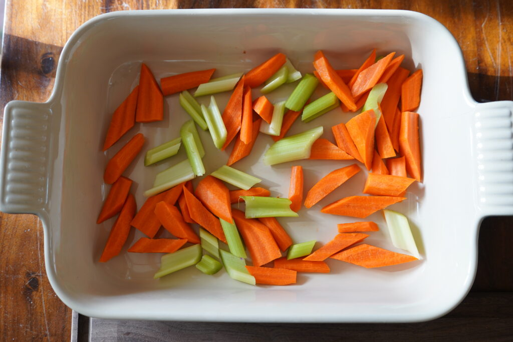 Chopped vegetables in a baking dish for the chicken recipe.