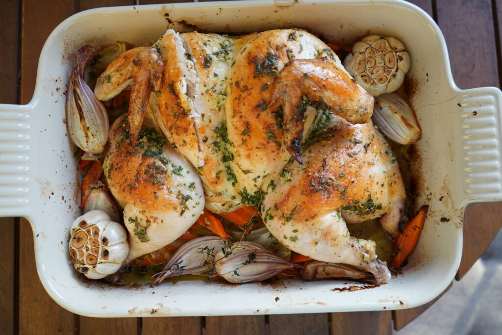 Whole roasted chicken with golden brown skin, ready to be served.