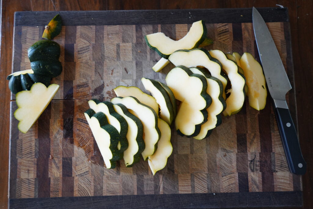 Acorn squash laid out out on a cutting board, cut up.