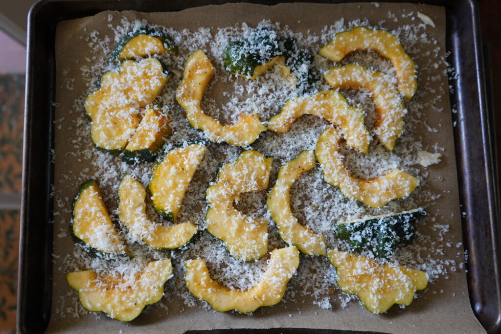 Acorn squash on a bed of shredded parmesan with parmesan also grated on top.