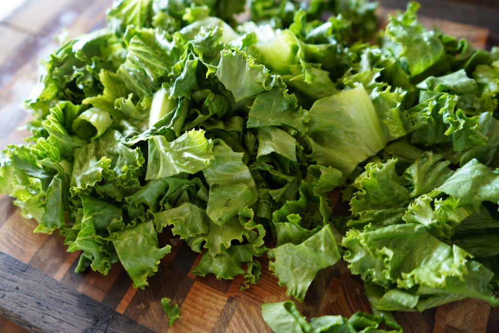 Chopped green lettuce on a cutting board.