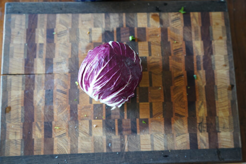 A whole Radicchio head on a cutting board.