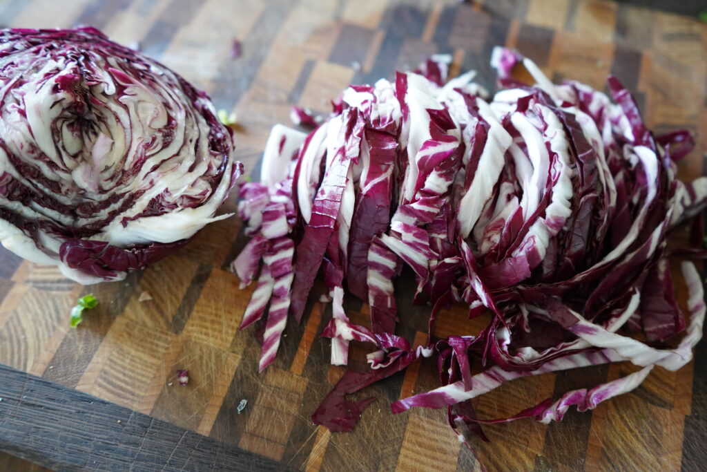 A Radicchio halved and half of it is chopped up.