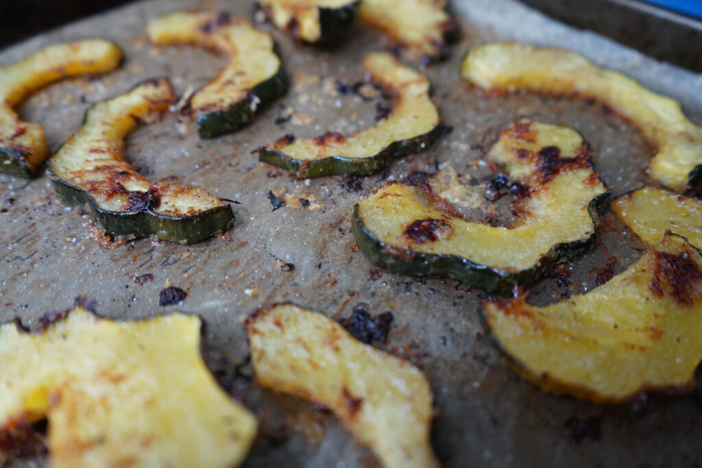 Cooked acorn squash on a baking sheet.