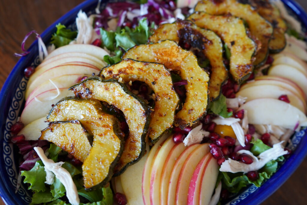 Acorn squash laying on a salad.