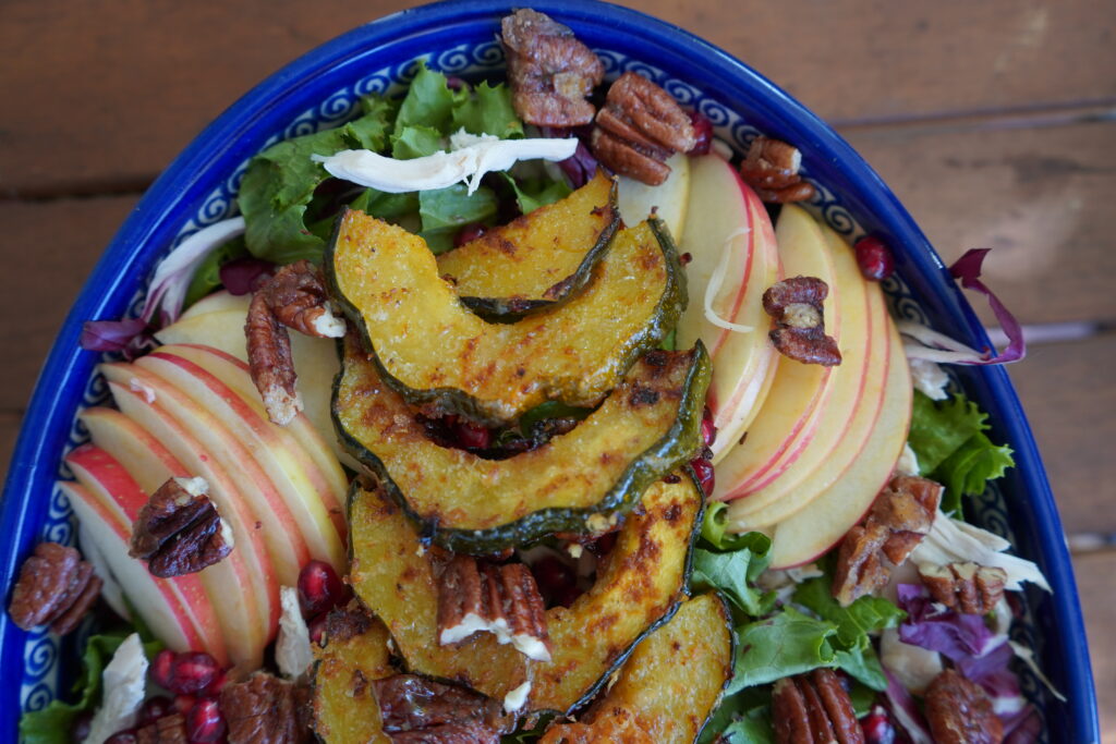 A fully loaded salad with acorn squash, apples and pecans.