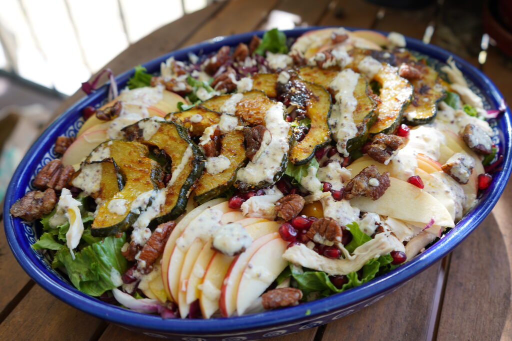 A fully loaded thanksgiving salad full of vegetables and fruit.