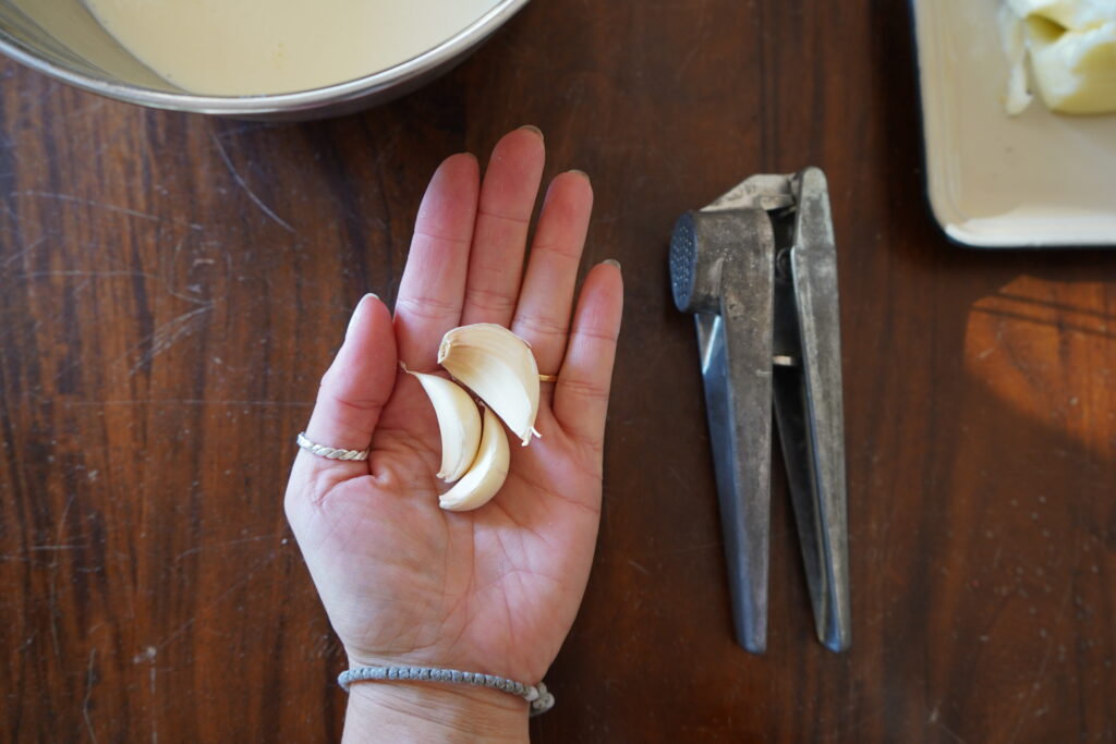 3 cloves of garlic in the palm of someone's hand