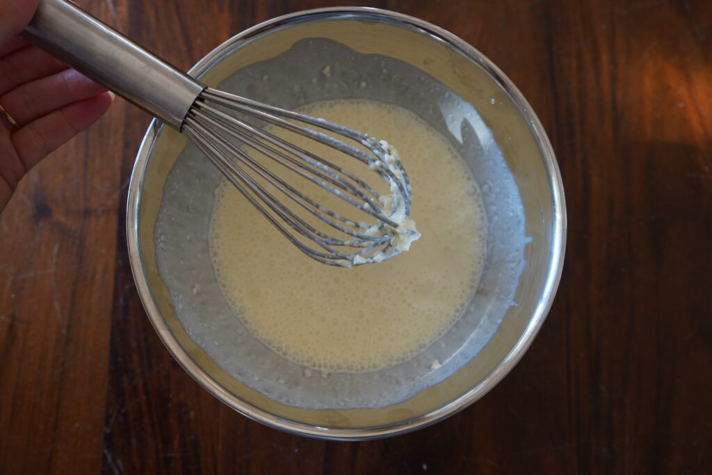 a bowl of heavy cream with a whisky stick over the bowl