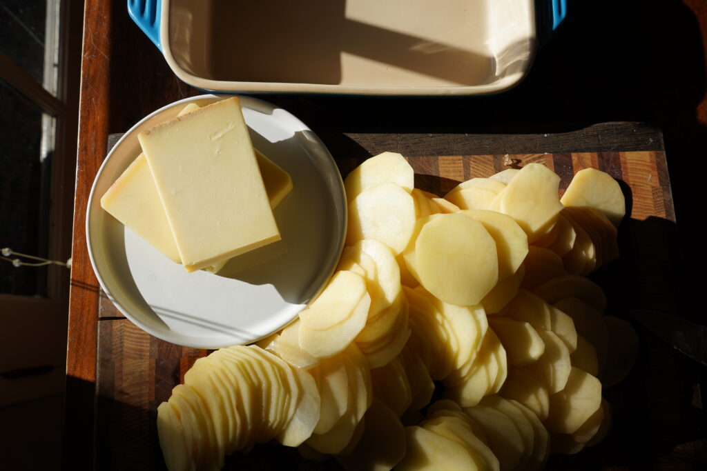 Golden potatoes on a cutting board that have been thinly sliced