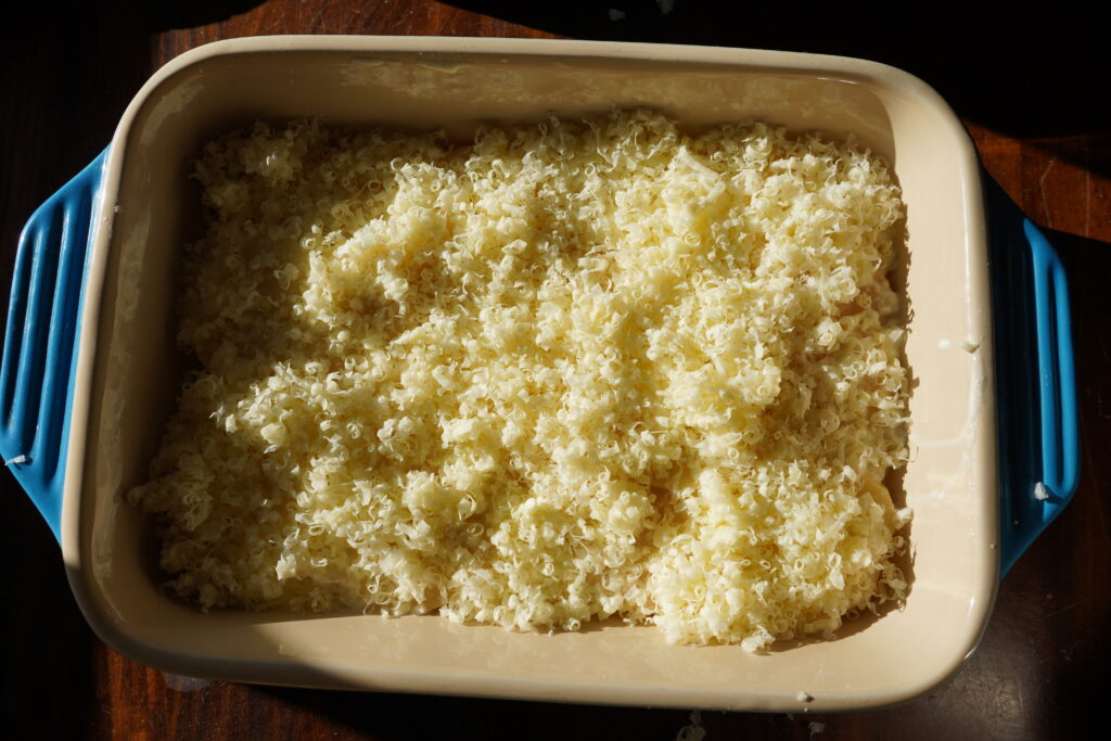 A baking dish with a thick layer of shredded cheese