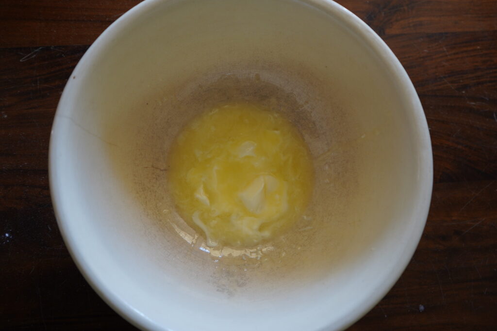 A mixing bowl with melted, soft butter at the bottom