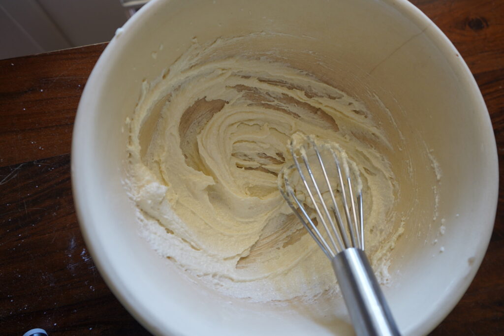 A mix bowl with butter and sugar mixed together to create a paste