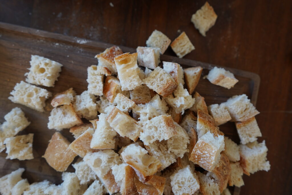 cubed sourdough falling off a cutting board