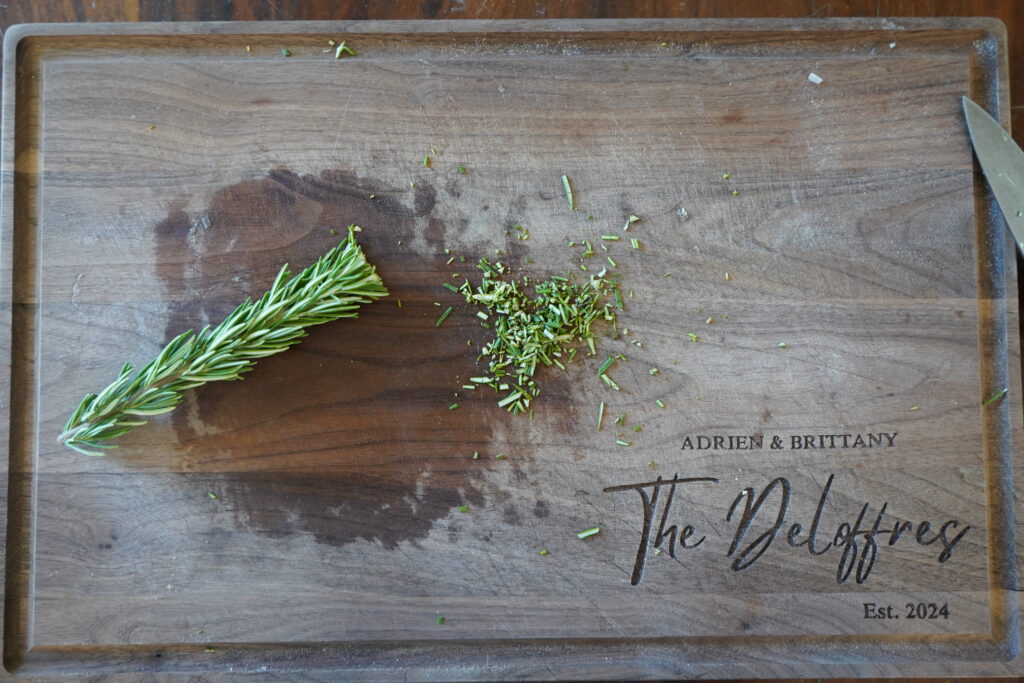 rosemary on a cutting board being chopped up