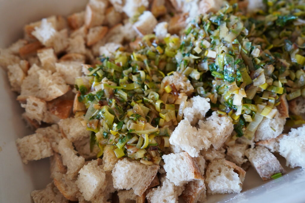 caramelized onion and link on top of a bed of bread cubes in s baking dish