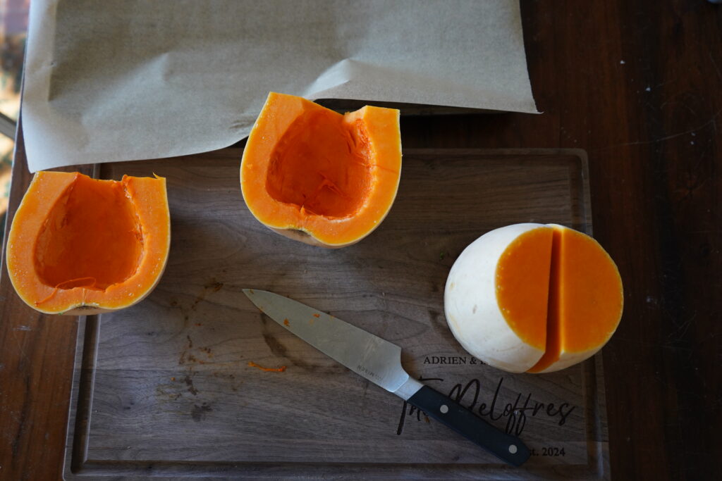 butternut squash on a cutting board that has been cut in half 