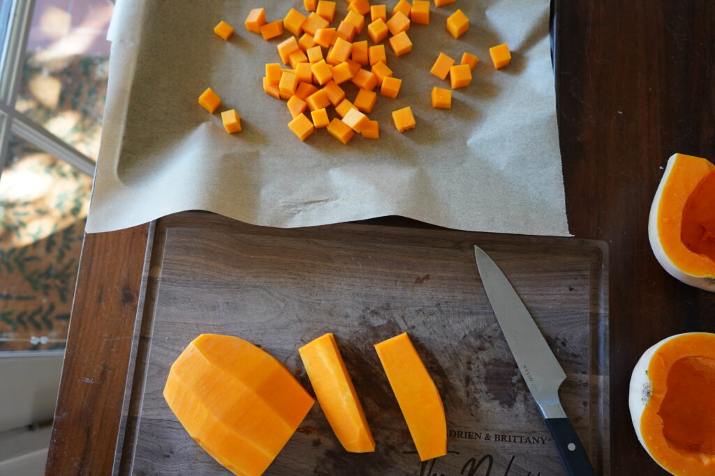 butternut squash that is being cut up into cubes