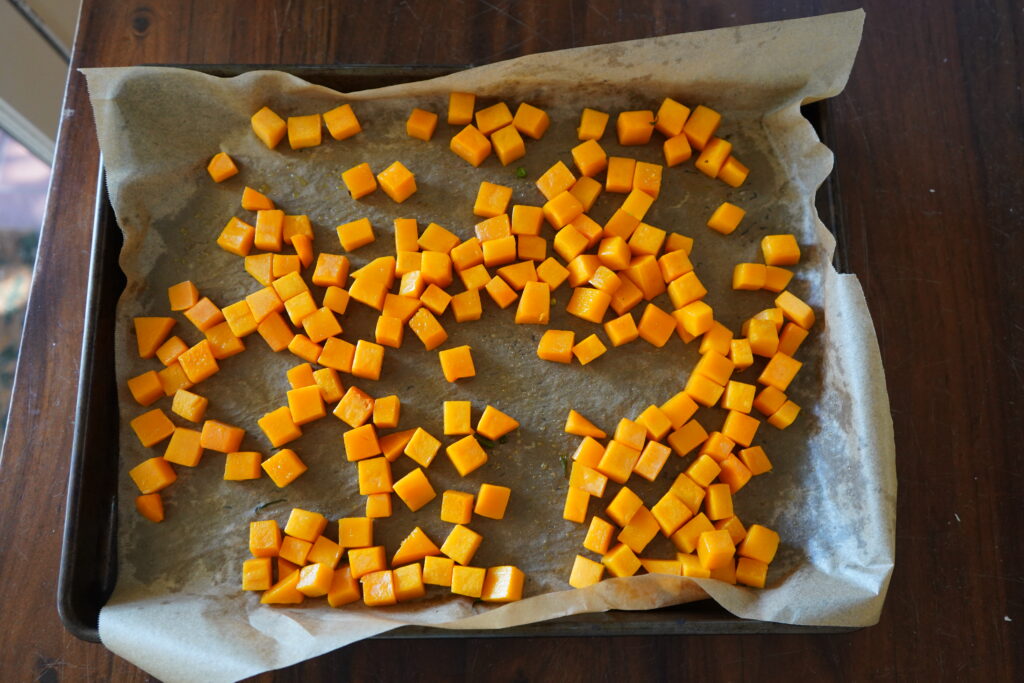 butternut squash on a baking tray tossed in olive oil