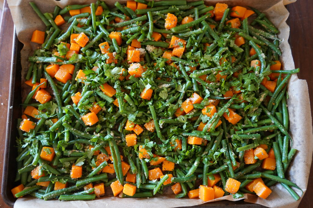 chopped cilantro over a bed of beans and squash ready to go in the oven