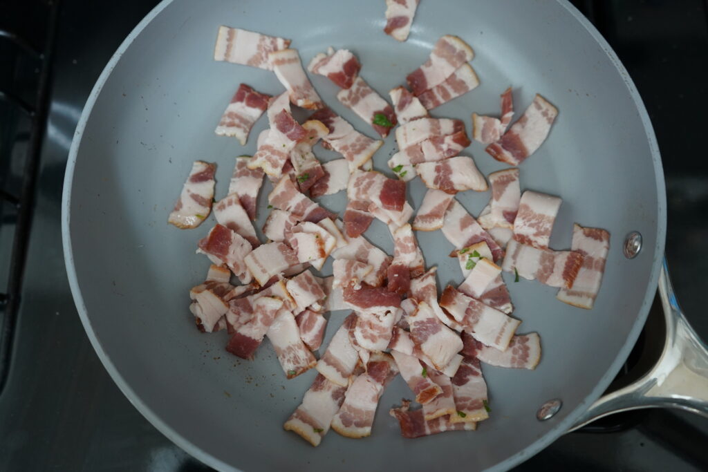 uncooked bacon in a cooking pan on the stove