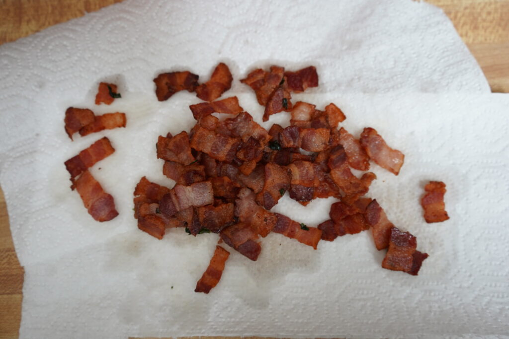 cooked bacon cooling on paper towels