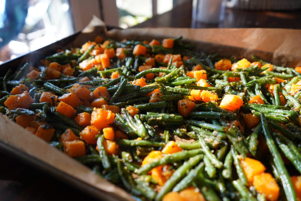 Green beans and butternut squash on a baking pan