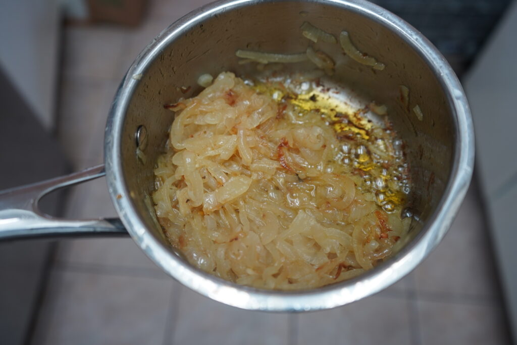 a sauce pan with caramelized onions inside