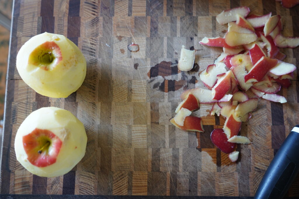 two peeled apples on a cutting board