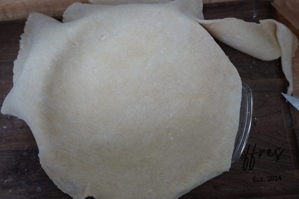 pie crust being trimmed to fit the pie dish