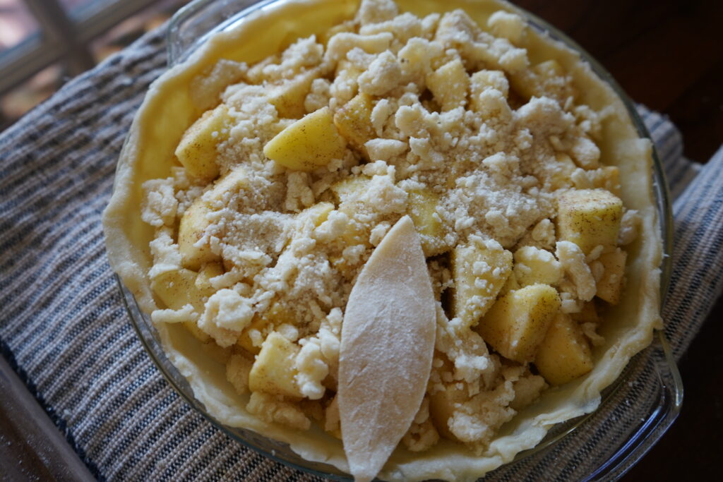 an apple pie with the crust being put on top