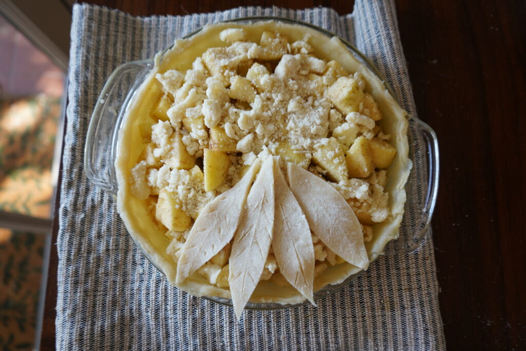 4 pie crust leaves on top of an uncooked apple pie