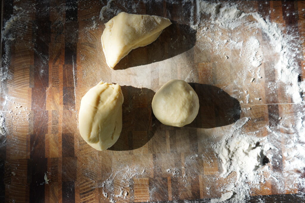 3 pieces of dough and one it in the shape of a ball