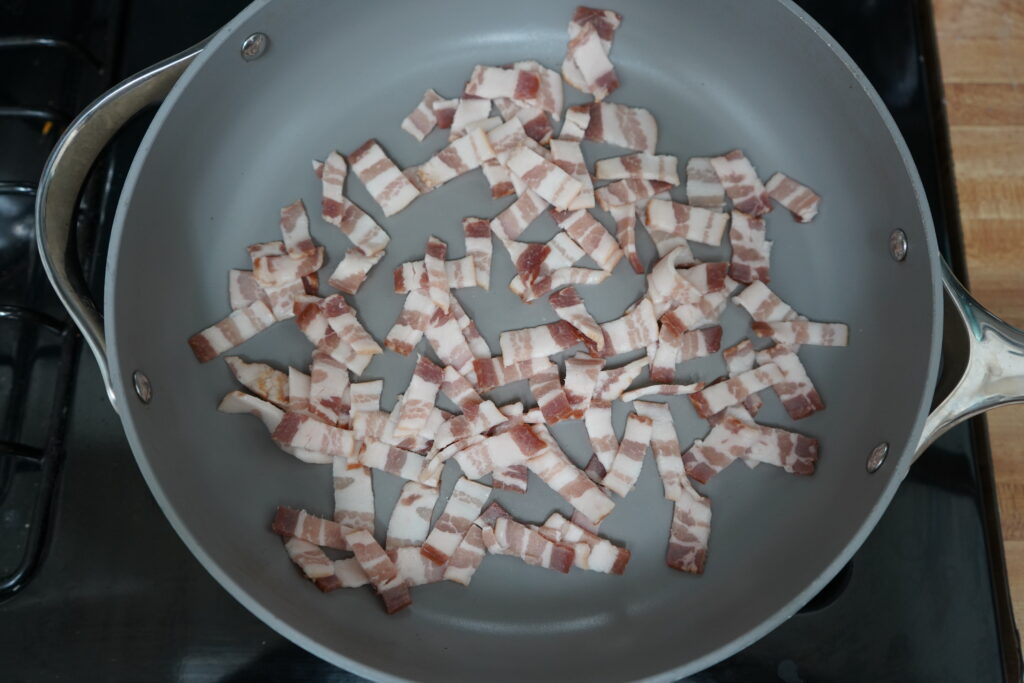 cut up bacon on a frying pan