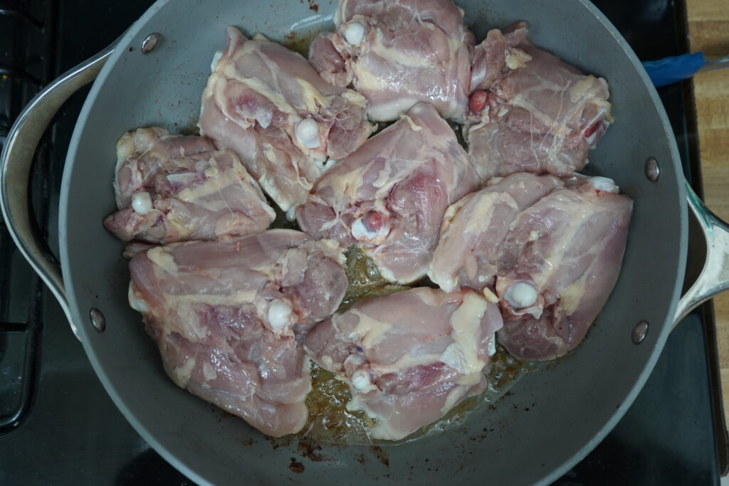 skin thighs in a pan skin side down cooking