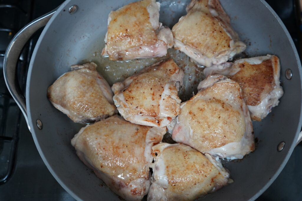 chicken thighs cooking in a pan