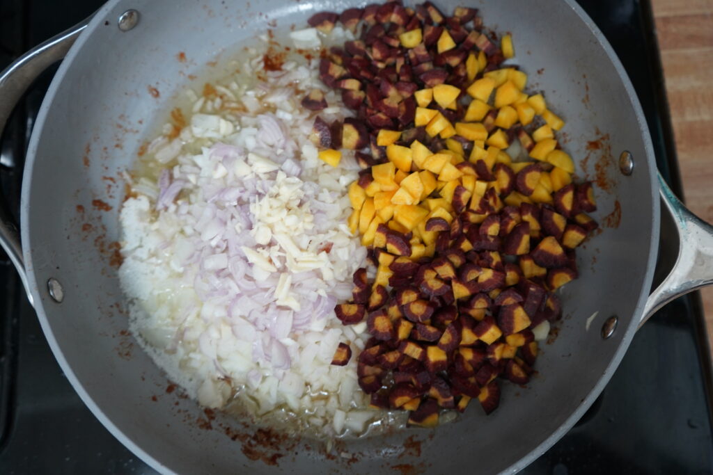 a pile of onions and carrots in a pan