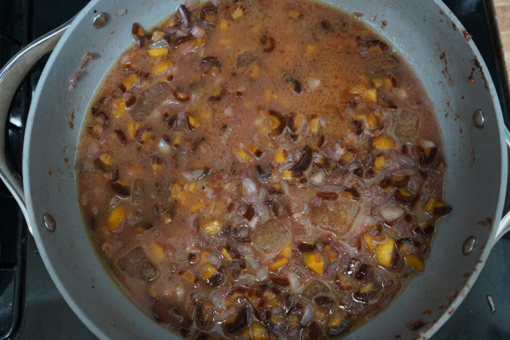 vegetables and wine being brought to a boil in a pan