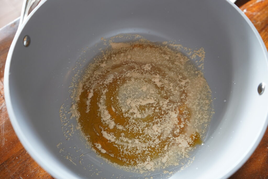 honey added to yeast and water in a mixing bowl