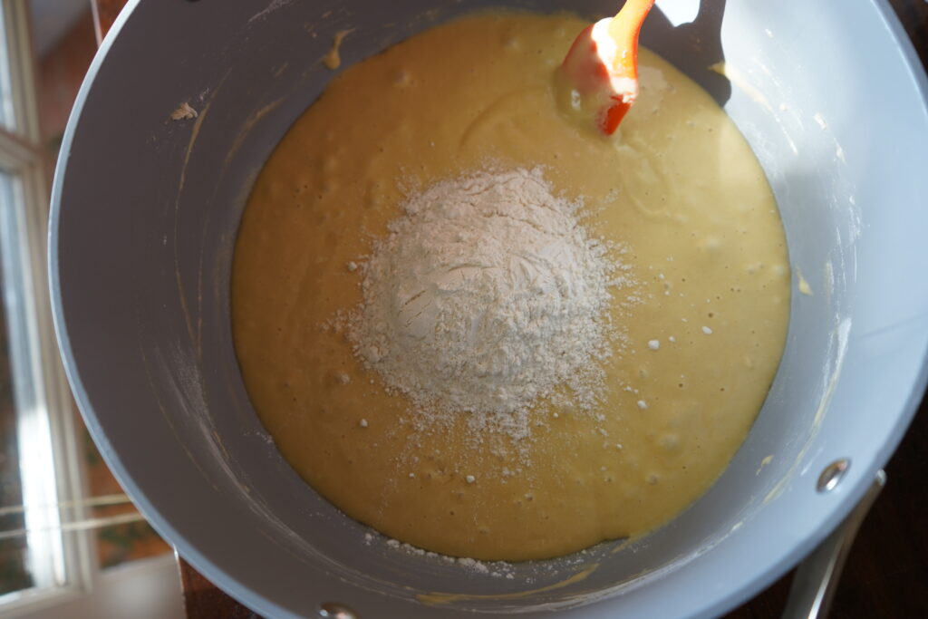 flour poured on top of dough in a mixing bowl