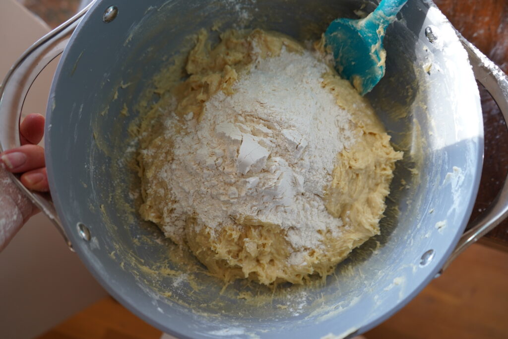 flour added to dough in a bowl