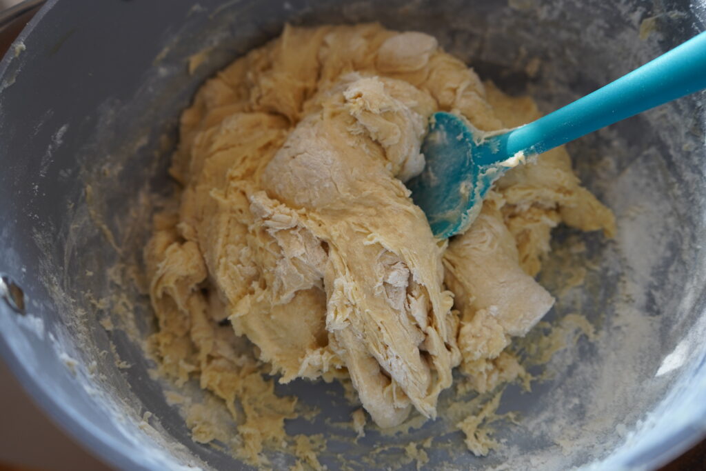 dough being kneaded with a spatula in abowl