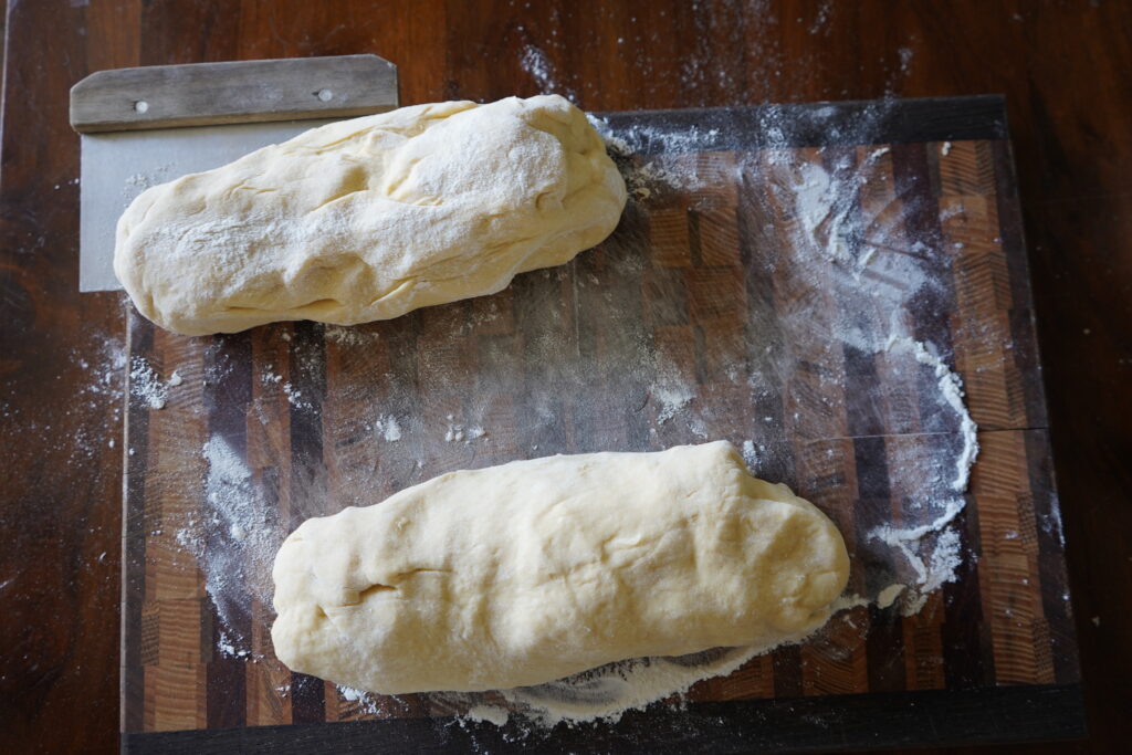 two oval shaped pieces of dough on a cutting board