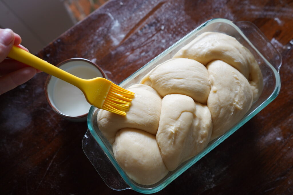 brioche dough being basted with milk before baking