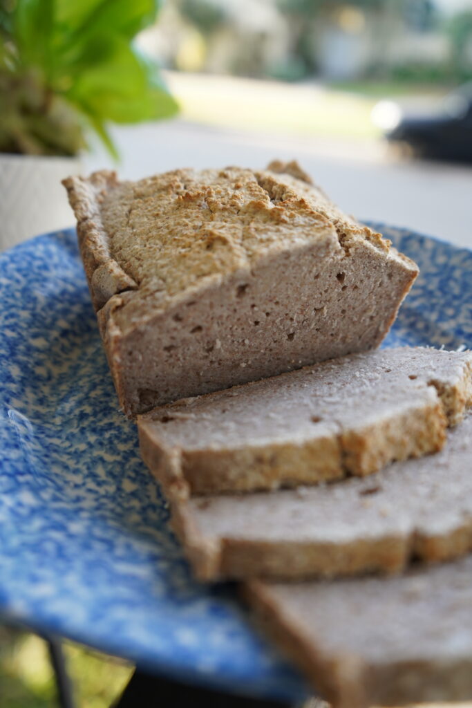 A buckwheat loaf of bread that has been sliced, sitting on a plate