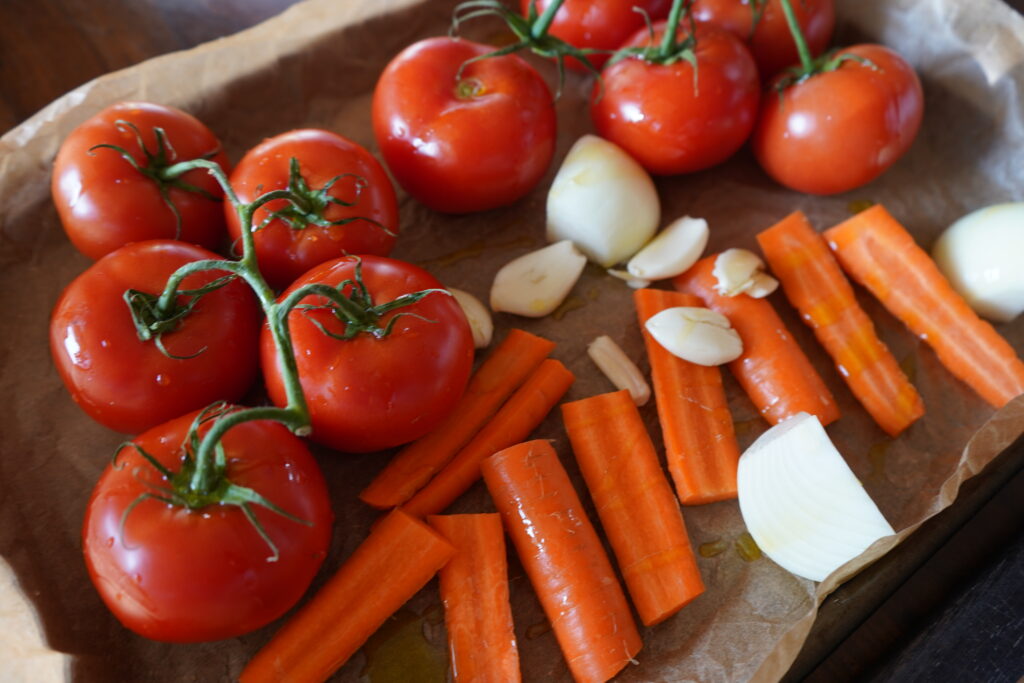 vegetables on a sheet pan with olive oil on top of them